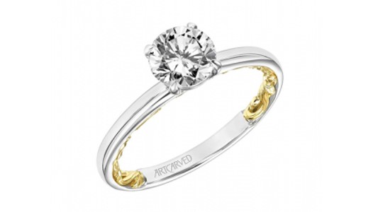 a white gold solitaire engagement ring with hidden yellow gold details inside the band