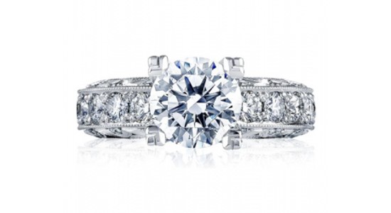 a white gold engagement ring featuring a round cut center stone and side stones