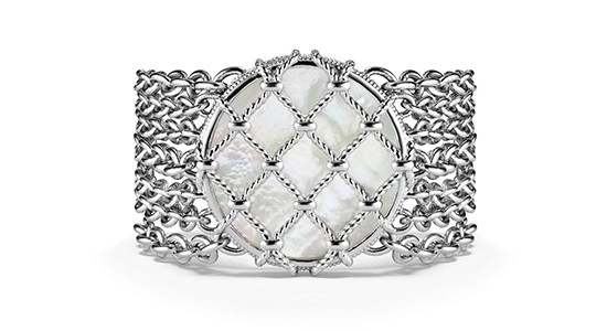 a white gold cuff bracelet featuring a large mother-of-pearl gem