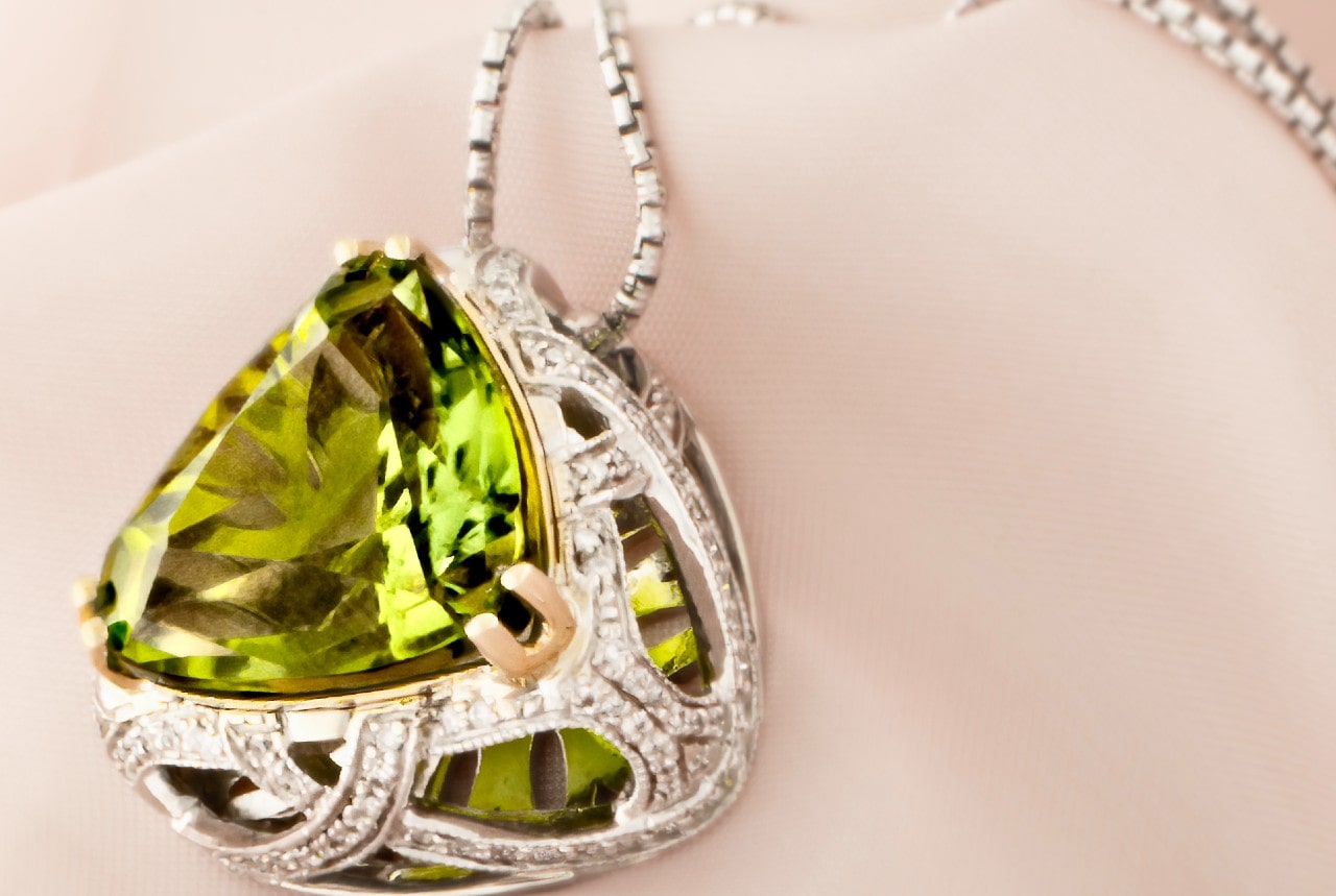 a peridot necklace in a silver setting with intricate details