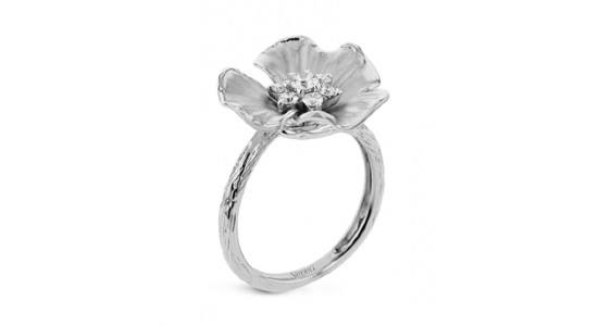 a white gold fashion ring with a floral motif and diamonds at its center