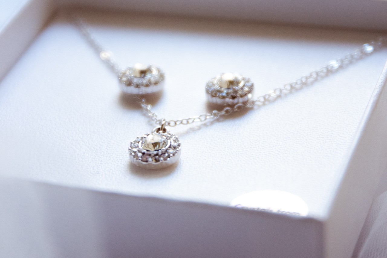 a white gold diamond necklace and matching earrings in a white gift box