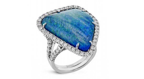 a white gold fashion ring featuring a blue and green opal surrounded by accent diamonds