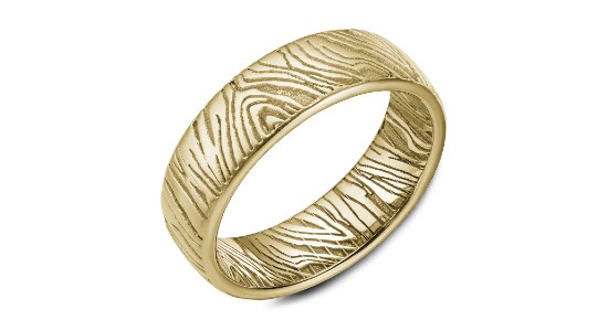 a yellow gold men’s wedding band with an engraved texture that looks like wood