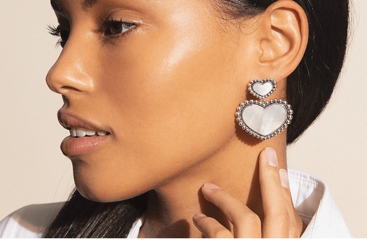 a woman facing the side and wearing a tiered heart earring by Lagos