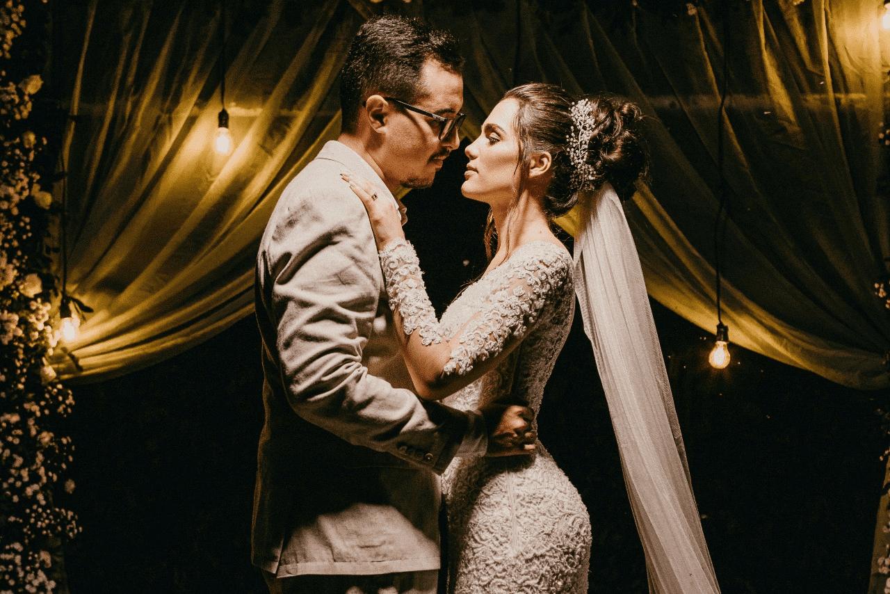 bride and groom embracing and wearing fine jewelry