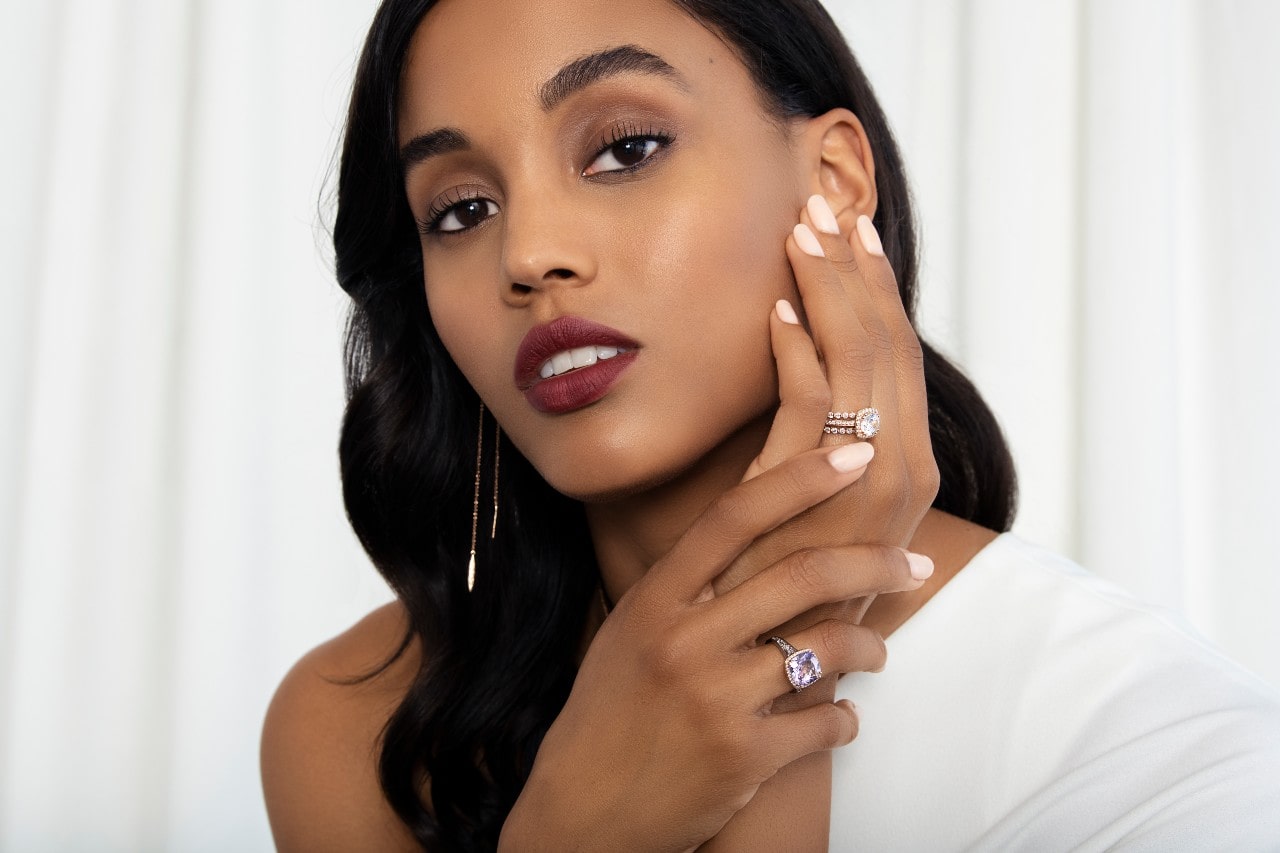 a woman touching her face and wearing a number of TACORI jewelry pieces