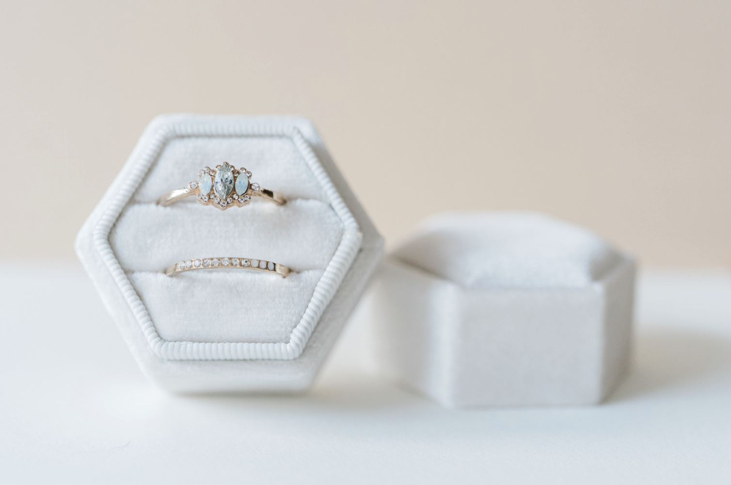 Rose gold marquise engagement ring and wedding band set in a white velvet box.