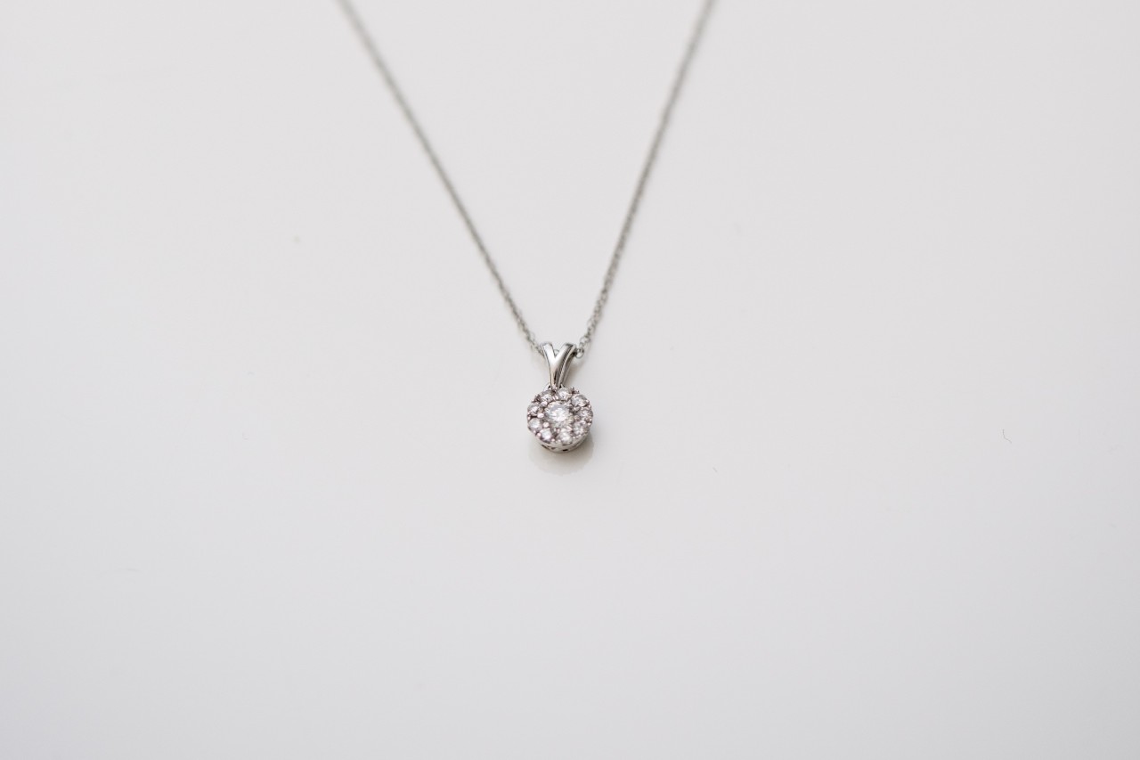 A lab-grown solitaire diamond necklace hangs from a chain. A lab-grown solitaire diamond necklace hangs from a chain.