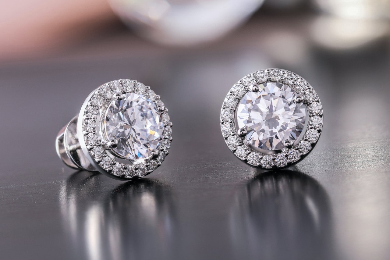 a pair of diamond earrings on a table