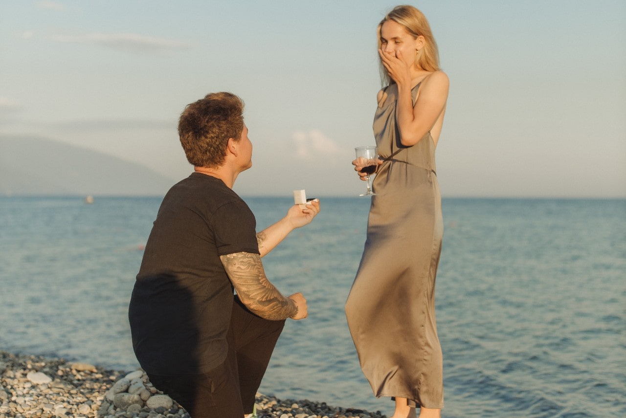 a man proposing to a woman on a beach